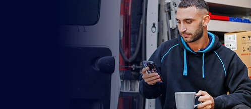 A plumber ordering plumbing supplies on a phone at a job site